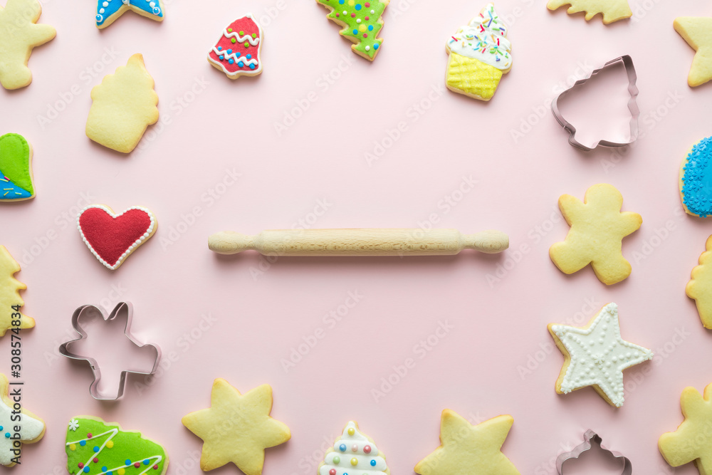 Flat lay christmas cookies pattern and rolling pin on pastel pink background minimal holiday creative concept. Flat lay christmas cookies pattern and rolling pin on pastel pink background minimal holiday creative concept.