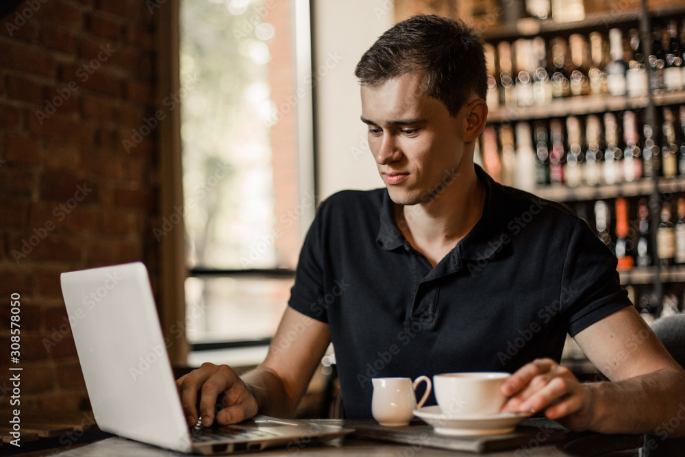 Businessman working on a laptop in a cafe. Businessman working on a laptop in a cafe.