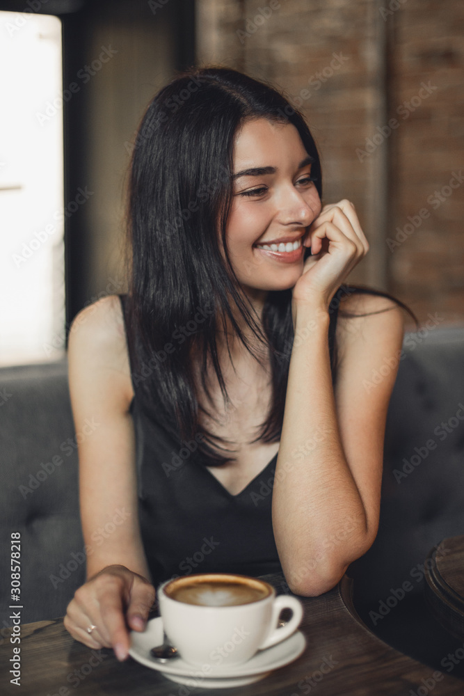Beautiful woman drinking coffee sitting in a cafe. Beautiful woman drinking coffee sitting in a cafe.