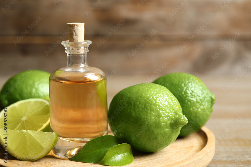 Lime essential oil and citrus fruits on wooden table, closeup Lime essential oil and citrus fruits on wooden table, closeup