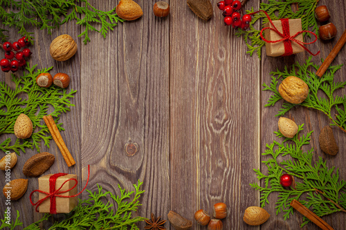 Boże narodzenie - tło drewniane z bakaliami, prezentami i gałązkami Tui