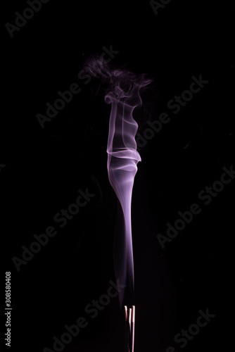 Beautiful purple rising trail of smoke on a black background