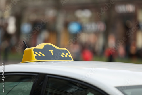 Fototapeta Naklejka Na Ścianę i Meble -  Taxi cab with yellow sign on city street, closeup