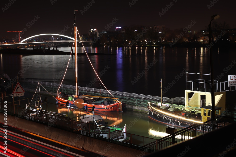 Obraz premium Bâteau illuminé la nuit sur le fleuve Rhône dans l'ancienne écluse de La Mulatière au sud de Lyon - Département du Rhône - Région Rhône Alpes - France