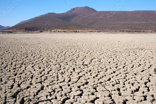 View over parched and empty dam, with cracked mud