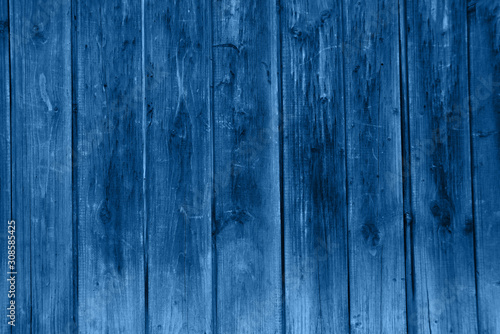 The back wall of the old barn in classic blue color tone. Background of old boards.