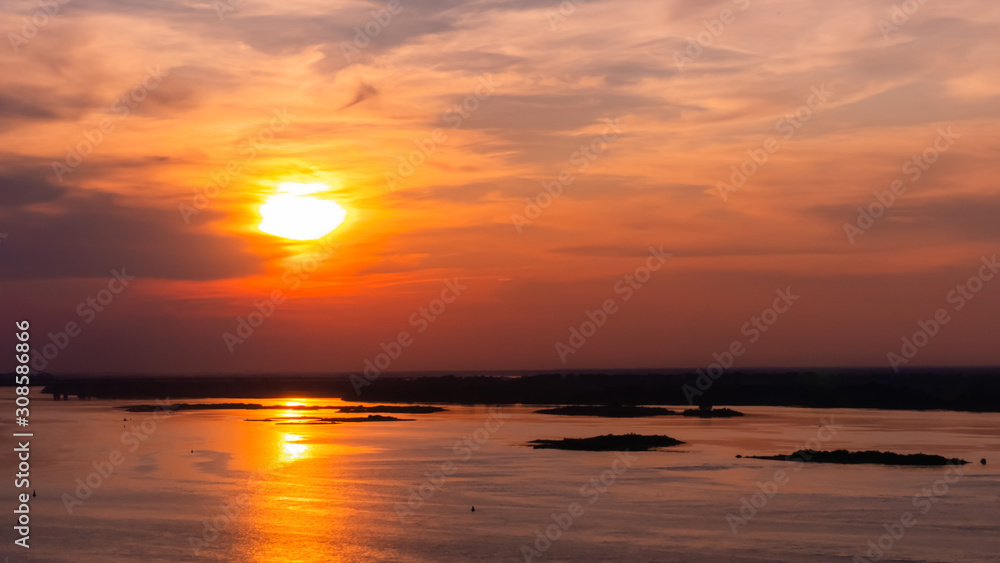 Dramatic colorful golden susnet with moving clouds on the Volga river. Evening time, warm illumination. Calm, peaceful, atmospheric view, relaxation concept