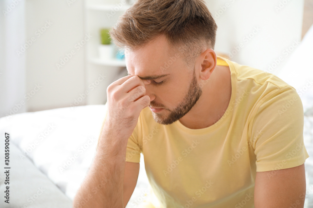 Young man suffering from headache at home Young man suffering from headache at home