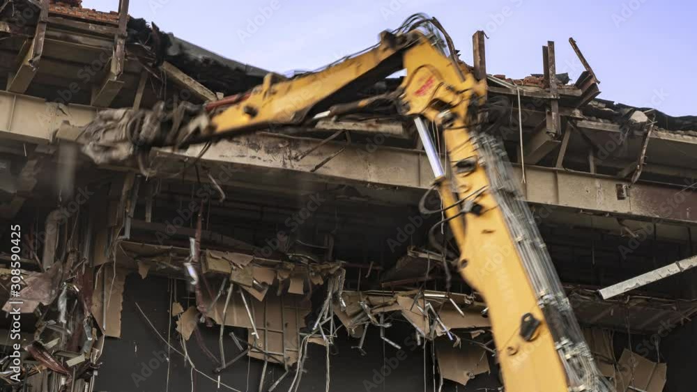 Destruction of the cinema building on a steel frame with a machine with hydraulic scissors, time lapse Destruction of the cinema building on a steel frame with a machine with hydraulic scissors, time lapse