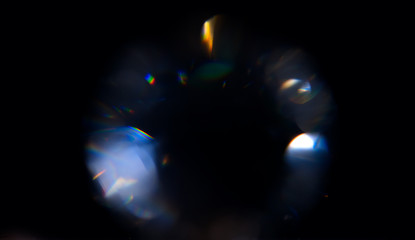 Lens Flare, Abstract Bokeh Lights. Leaking Reflection of a Glass, Crystal, Defocused Shining Colorful rainbow Light Leaks, Rays on Black Background