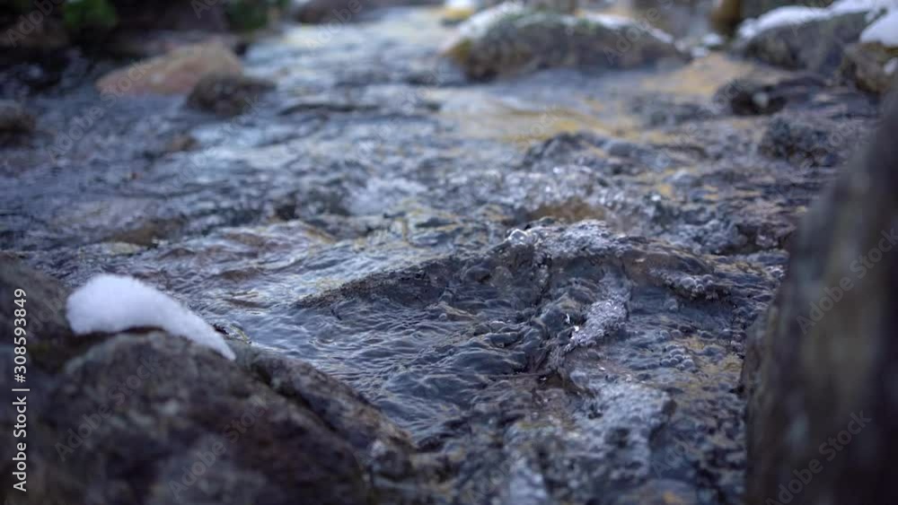 Fast flowing clear melting water in creek in mountain river at early spring Fast flowing clear melting water in creek in mountain river at early spring