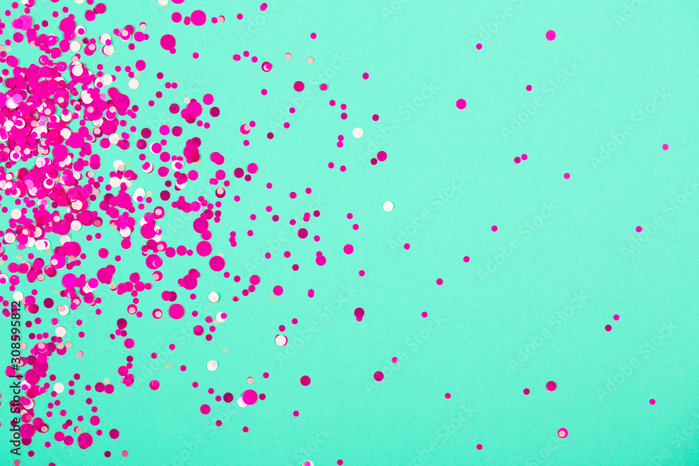 Falling confetti on green pastel background. Holiday and party concept.