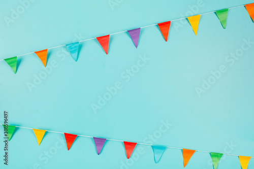 Multicolored paper flags on blue background. Festive concept.