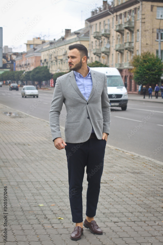 Portrait of a businessman on the street near the road of a European city. A bearded handsome man dressed stylishly. Fashionable guy hipster. Stock photos Portrait of a businessman on the street near the road of a European city. A bearded handsome man dressed stylishly. Fashionable guy hipster. Stock photos