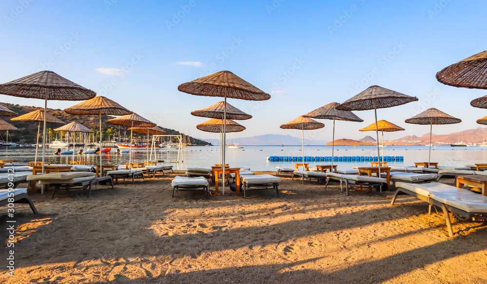 Beautiful beach on the shores of the calm blue bay of the Aegean Sea in the early morning. Beach vacation and holiday destination concept. Bitez, Bodrum, Turkey