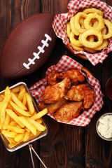 chicken wings, fries and onion rings for football on a table. Great for Bowl Game party