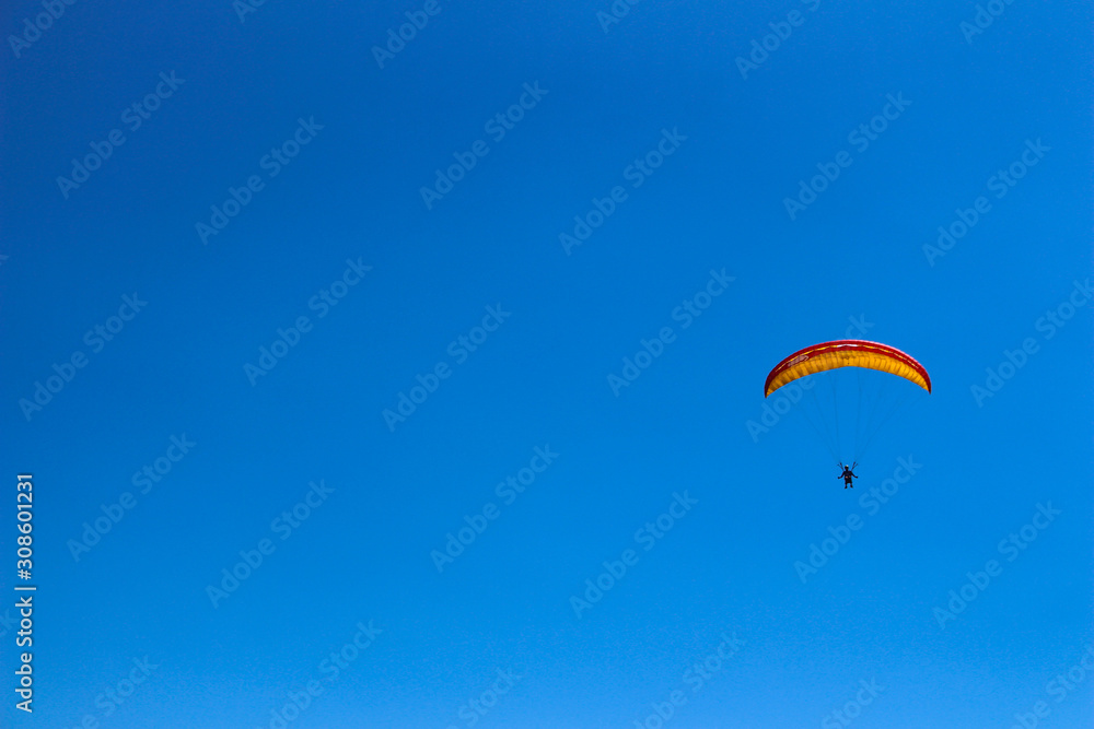 a paraglider flying in blue sky landscape in Indonesia a paraglider flying in blue sky landscape in Indonesia