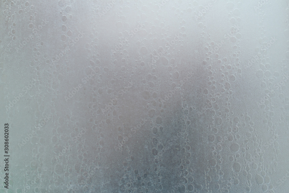 human body through a shower screen with drops on a light background