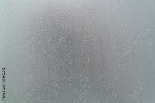 human body through a shower screen with drops on a light background