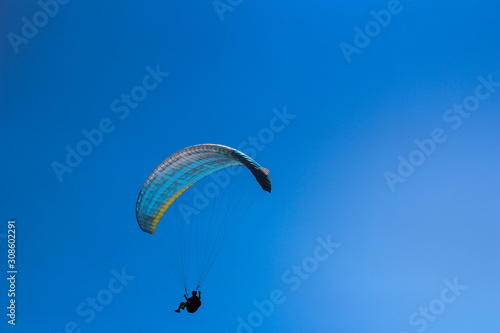 a paraglider flying in blue sky landscape in Indonesia