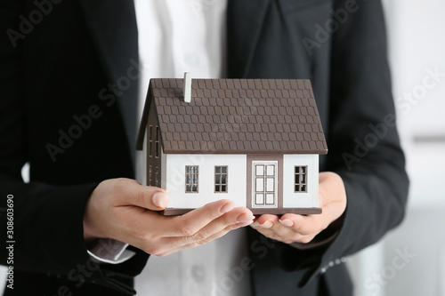 Real estate agent with model of house, closeup