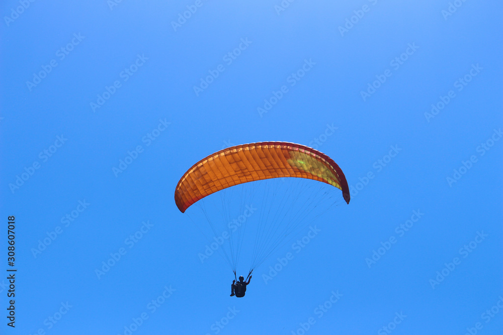 a paraglider flying in blue sky landscape in Indonesia