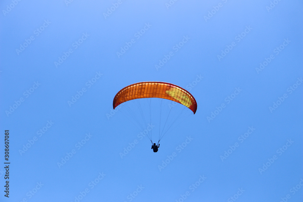 a paraglider flying in blue sky landscape in Indonesia a paraglider flying in blue sky landscape in Indonesia