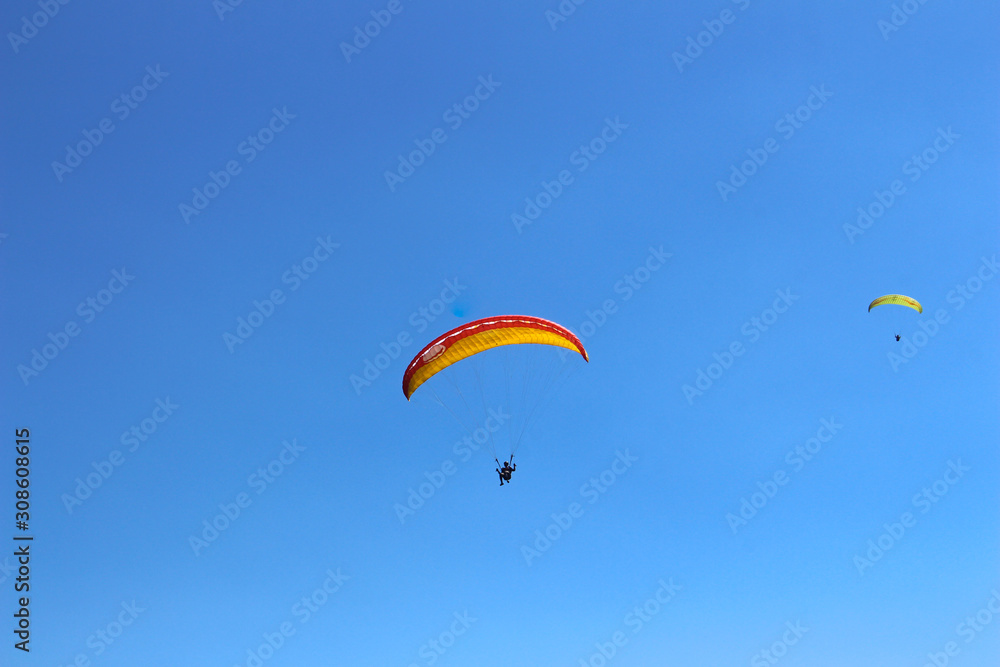 a paraglider flying in blue sky landscape in Indonesia a paraglider flying in blue sky landscape in Indonesia