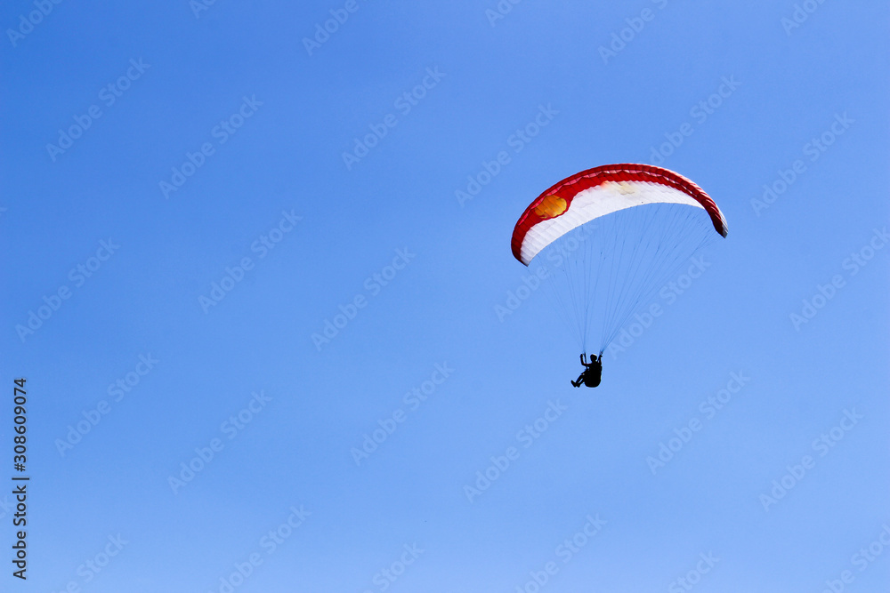 paraglider flying in blue sky on valleys landscape in Indonesia paraglider flying in blue sky on valleys landscape in Indonesia