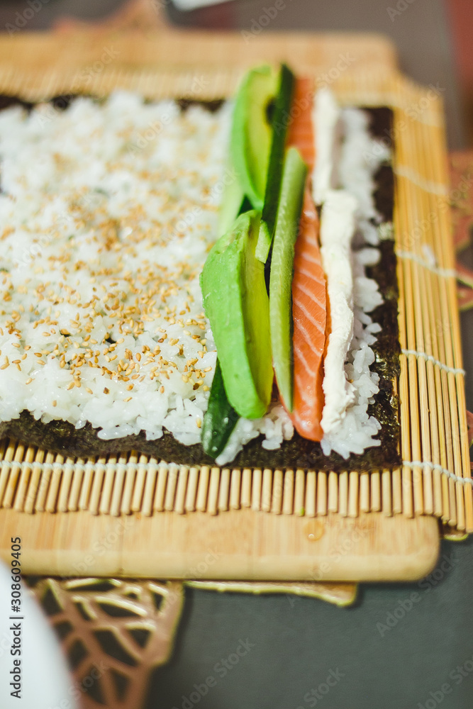 avocado and salmon. process of making homemade sushi roll avocado and salmon. process of making homemade sushi roll