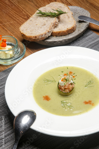 Chilled cucumber soup with salmon tartare. Exquisite dish. Creative restaurant meal concept.