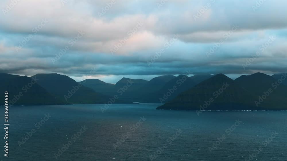 Evening timelapse with moving clouds and blue mountain peaks in the summer Faroe Islands, Denmark. UHD 4k video Evening timelapse with moving clouds and blue mountain peaks in the summer Faroe Islands, Denmark. UHD 4k video