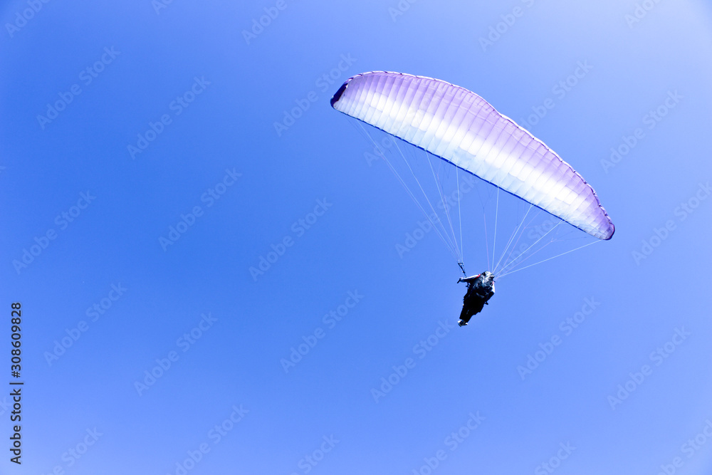 paraglider flying in blue sky on valleys landscape in Indonesia paraglider flying in blue sky on valleys landscape in Indonesia
