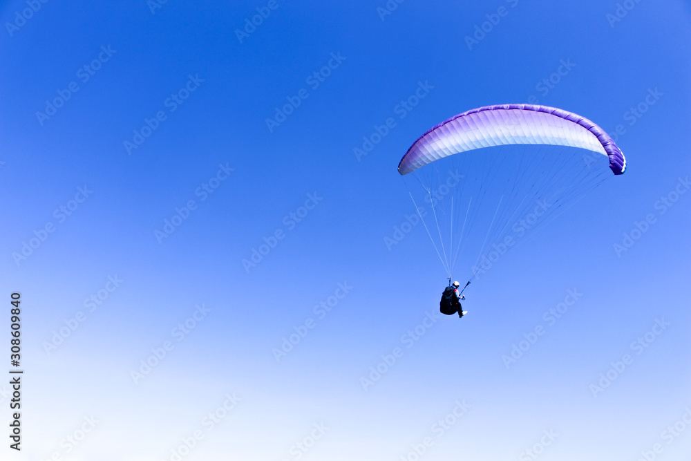 paraglider flying in blue sky on valleys landscape in Indonesia paraglider flying in blue sky on valleys landscape in Indonesia