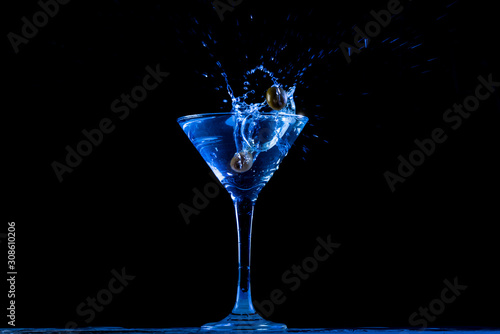 Blue Martini with crashing olives on black background