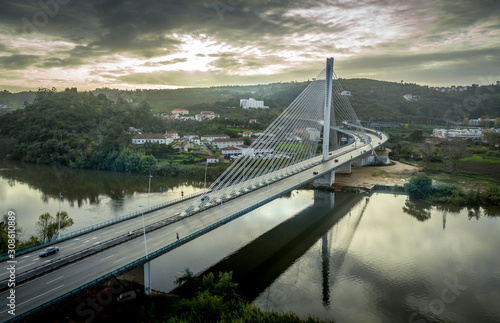 Cable-stayed bridge with semi-fan system steel structure Ponte Rainha Santa Isabel in Coimbra over the Mondego river during sunset © tamas
