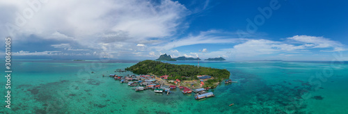 Aerial view of the Selakan island with crystal clear water, blue sky and mountain background in Semporna, Sabah, Malaysia.