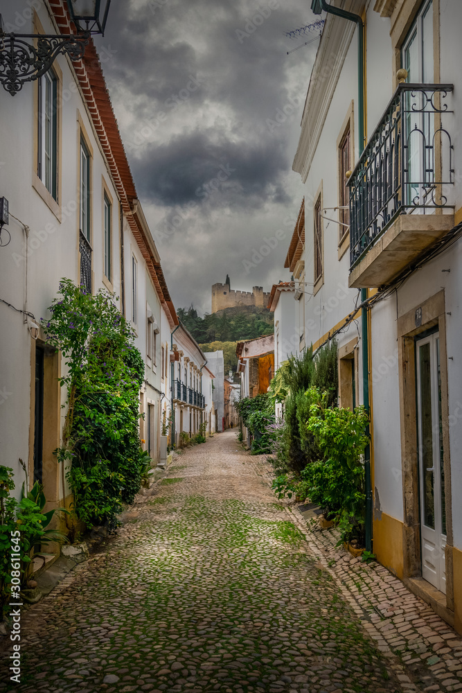 Medieval center quiet alley before the rain in Tomar Portugal with view of the templar castle