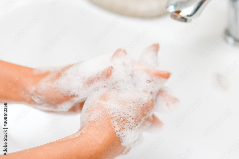 Fototapeta premium Hygiene concept. Washing hands with soap under the faucet with water