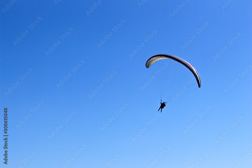 a paraglider flying in blue sky landscape in Indonesia a paraglider flying in blue sky landscape in Indonesia