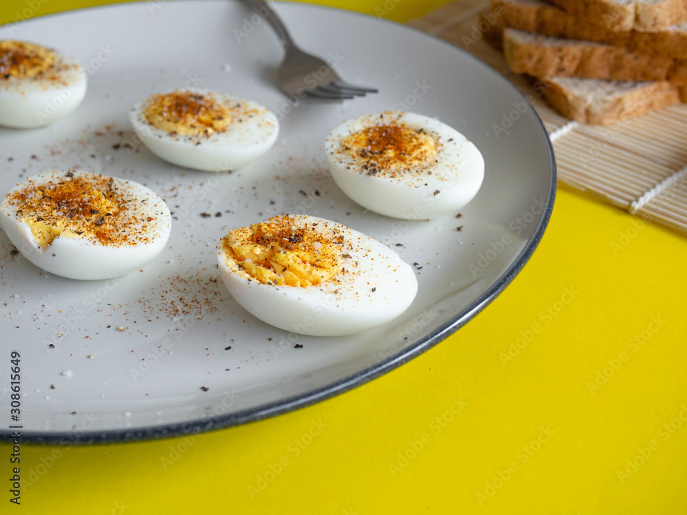 ฺBoiled egg topped with Cayenne pepper Pepper and Salt on a white dish,Egg colors white and yellow,Eat with bread ฺBoiled egg topped with Cayenne pepper Pepper and Salt on a white dish,Egg colors white and yellow,Eat with bread