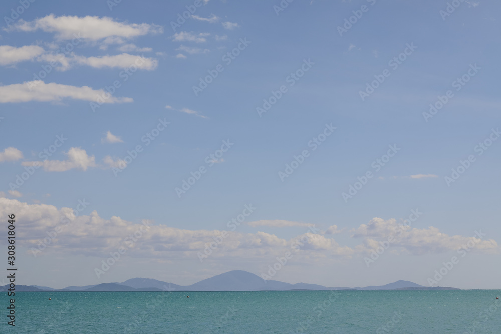 Seaside view with mountains in the distance, bright blue tropical waters of North Queensland off Cape Gloucester
