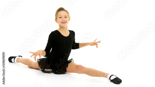 Slender girl gymnast doing the twine. The concept of children's
