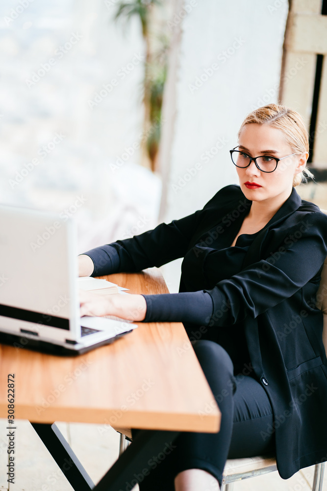 Computer technology and business. Online communication, international partners collaboration. Young businesswoman working on laptop at modern office room Computer technology and business. Online communication, international partners collaboration. Young businesswoman working on laptop at modern office room