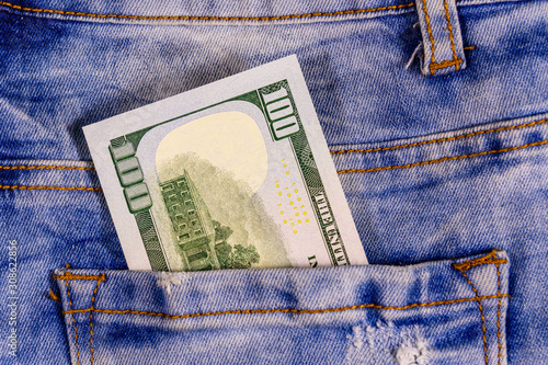 American one hundred dollar banknote in a pocket of blue jeans