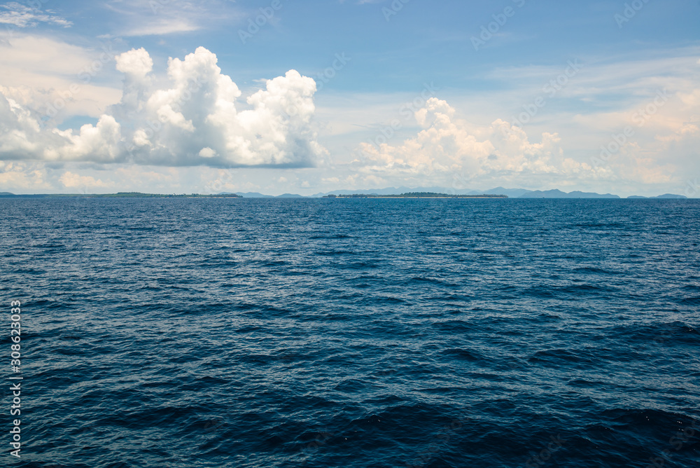 Obraz premium The deep ocean view with the yellow sunlight and cloudy sky