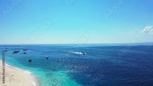 Abstract summer vacation background, sunny day, boats sailing in the tropical sea near white sand beach photo