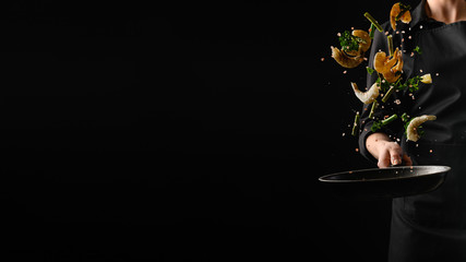 Seafood, frying shrimp with vegetables, a chef on a black background. Advertising banner for the sale of seafood, on a black background for design