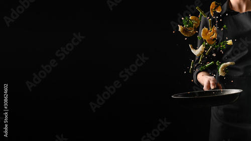 Foto Seafood, frying shrimp with vegetables, a chef on a black background