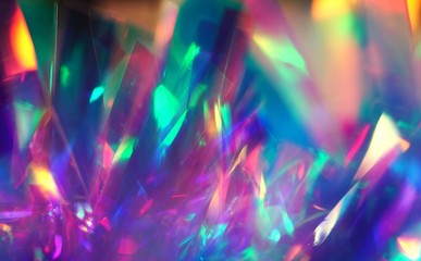 Holographic iridescent color wrinkled foil. Abstract glitter texture with neon purple blue ultraviolet pink colors